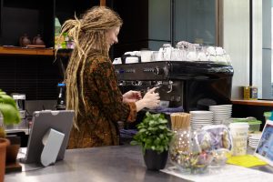 Cafe barista making coffee in small business cafe in the Melbourne CBD.