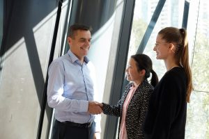 Small business people shaking hands after resolving their small business dispute through mediation.