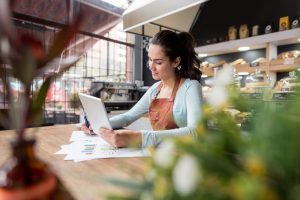 Cafe business owner looking at an ipad at a desk